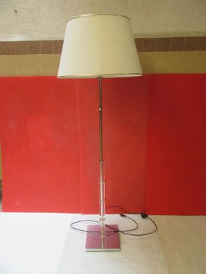 une lampe posée sur une table, avec un mur rouge en arrière-plan
