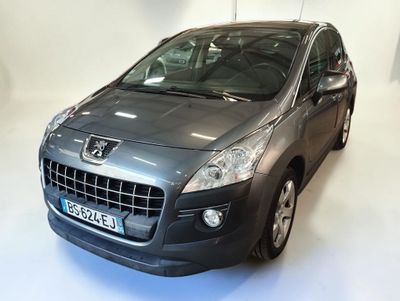 La voiture grise est garée dans une pièce blanche au sol blanc.
