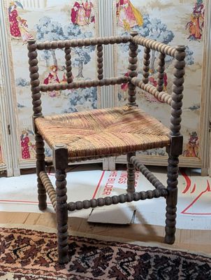 a wooden chair with a woven seat on a rug