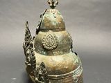 an old bronze bell with a dragon head on top of it