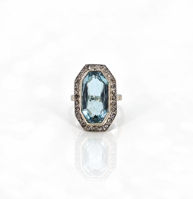 une bague sertie d'une topaze bleue et de diamants sur fond blanc