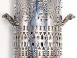 a silver candle holder with a bird on it