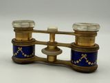 une paire de jumelles dorées et bleues sur fond blanc