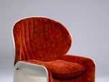 an orange and white chair sitting on top of a white floor