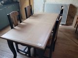 une table et des chaises dans une pièce, avec un radiateur en arrière-plan