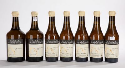 six bottles of wine are lined up in a row on a white surface
