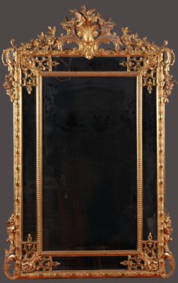 an ornate gold framed mirror on a wall with a black background