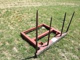 a small square made out of wood and nails on the grass