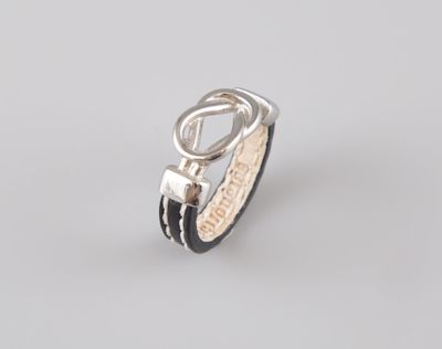 un gros plan d'une bague en argent ornée d'un bracelet en cuir noir