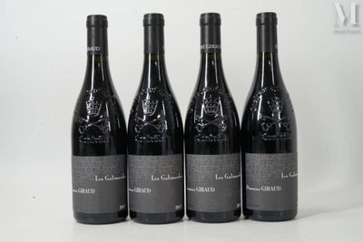 quatre bouteilles de vin sont alignées sur une surface blanche
