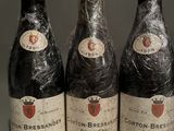 three bottles of wine are wrapped in plastic on a table