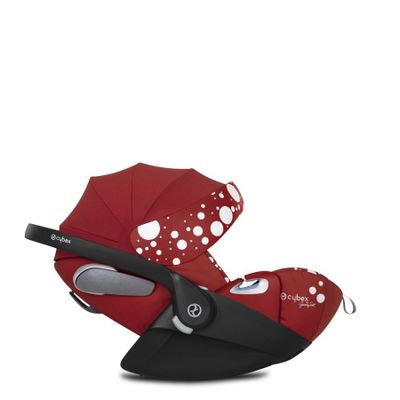 une poussette rouge à pois avec un guidon noir