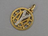 un gros plan d'un pendentif en or et diamants représentant une initiale