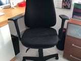 une chaise de bureau noire sur laquelle est collé un autocollant bleu