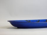blue bowl with black birds on it sitting on a white surface
