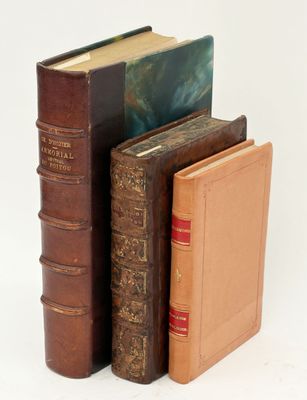 trois livres posés l'un à côté de l'autre sur une surface blanche