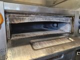 a large metal oven that is in the middle of a kitchen