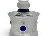 a small glass jar with a blue button on it