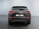 the rear end of a grey suv parked in a white room