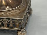 a silver plate with a candle on it on a table