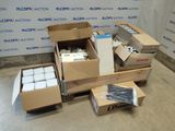 several boxes of assorted items sit on a floor in front of a wall