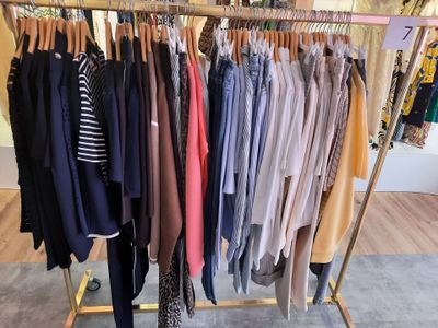 beaucoup de vêtements suspendus à une étagère dans un magasin