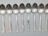 six silver spoons and two silver spoons are lined up on a table