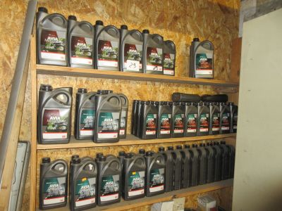 de nombreuses bouteilles d'huile moteur sur une étagère dans un garage