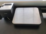 a laptop and printer sitting on a desk next to a window