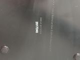 a close up of a black clock on a white table