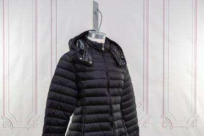 le manteau est noir et comporte une capuche