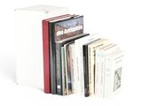 several books are stacked on top of each other on a white surface