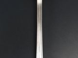 a silver spoon with a spoon handle on a black surface
