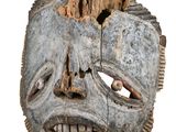 an old wooden mask with a hole in the middle of it ' s face