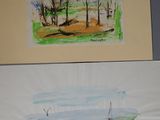 deux tableaux accrochés au mur d'une salle de bains équipée de toilettes