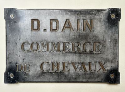une pancarte accrochée au mur sur laquelle on peut lire « D'Bain Commerce de Cirvaux »