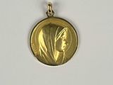 Gros plan sur une médaille d'or portant le visage d'une femme
