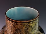 a black and gold vase sitting on a table