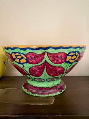 un bol coloré posé sur une table à côté d'un vase jaune