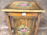 une petite armoire en bois décorée de fleurs peintes