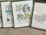 three framed pictures of plants and flowers on a table in front of a window