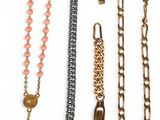 many different types of necklaces on a white surface