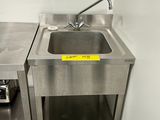 un évier en inox et un plan de travail en inox dans une petite cuisine