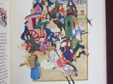 an open book with a picture of people on horseback