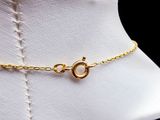 a close up of a gold necklace on a mannequin mannequin