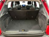 the back of a red car with its trunk open and the seats folded down