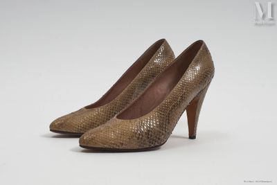 une paire d'escarpins en peau de serpent marron sur fond blanc