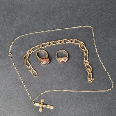 un collier, une bague et une croix posés sur une table