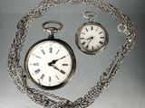 une montre de poche en argent avec une chaîne et une montre de poche en argent avec une chaîne