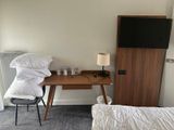 a small desk with a television on it in the corner of a room